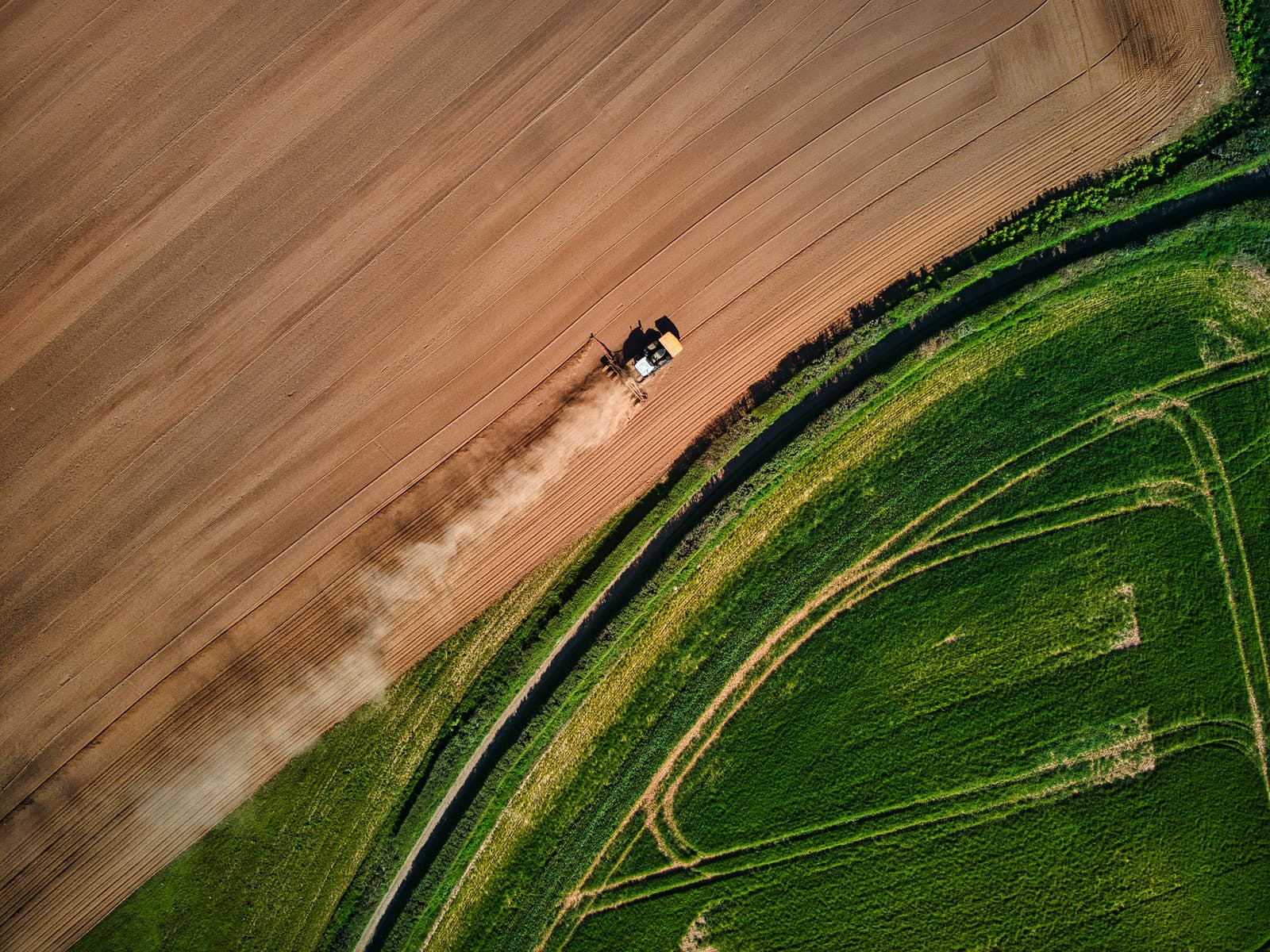 Aerial view of agricultural land with a tractor working a field